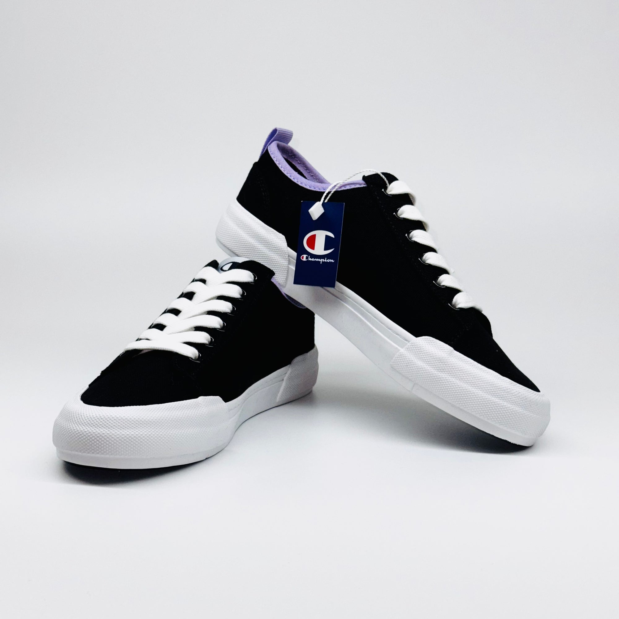 Жіночі кеди Champion Low Cut Shoe Revoli Nbk: один кросівок поверх іншого, поєднання чорного та фіолетового.