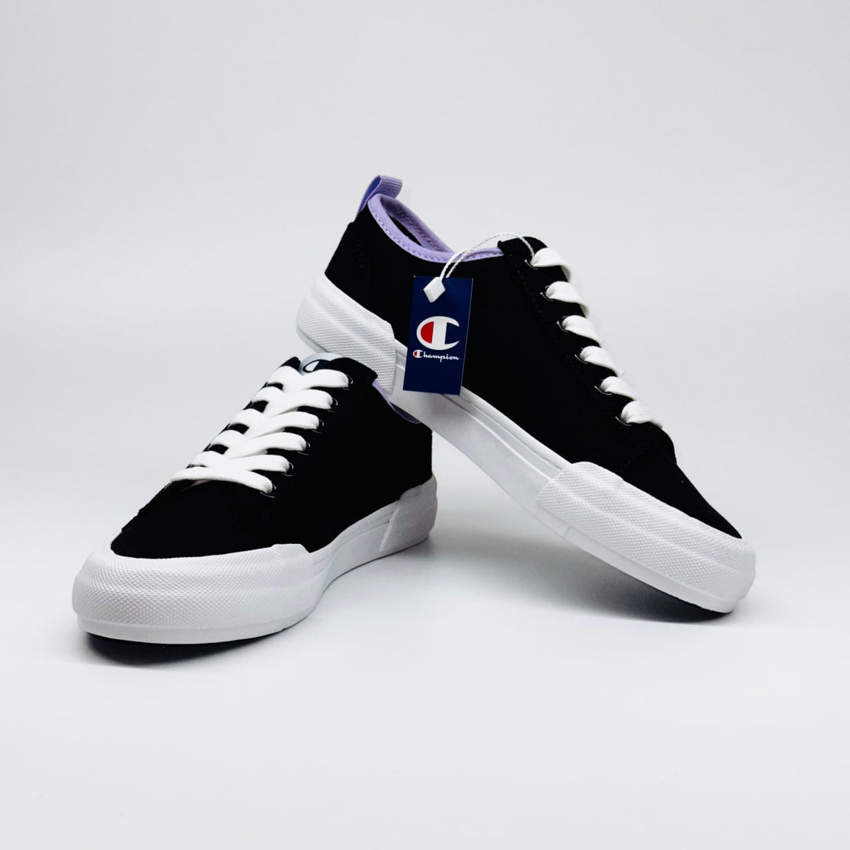 Жіночі кеди Champion Low Cut Shoe Revoli Nbk: один кросівок поверх іншого, поєднання чорного та фіолетового.